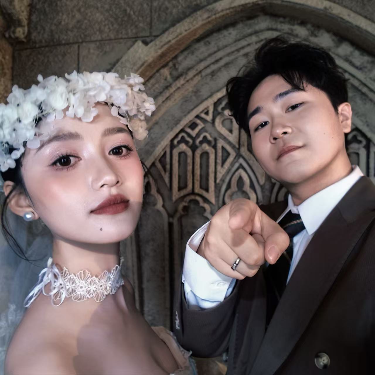 新人用手比出爱心的婚礼纪念照